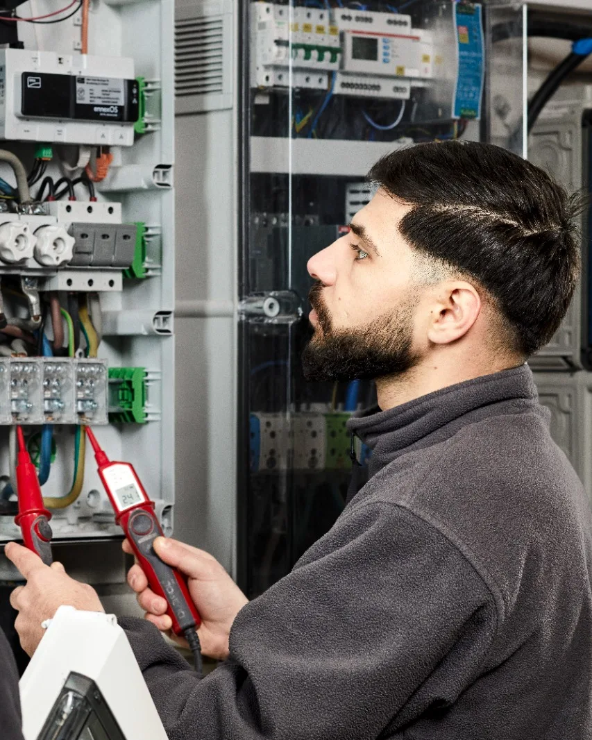 Monteur von Miton Elektro misst mit dem Prüfstift die Spannung an einer Verteilung.