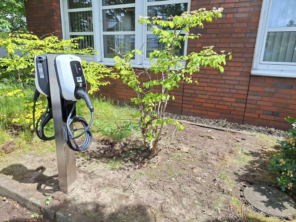 Zwei von Miton Elektro installierte Wallboxen auf einer Standsäule vor einem Gewerbegebäude.